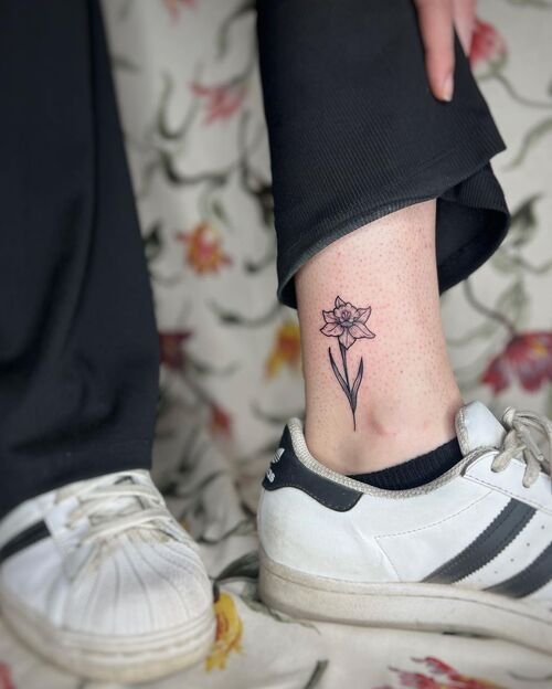Hand poked fern tattoo on the ankle.